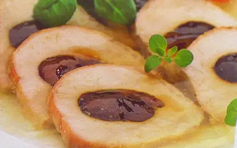 Schab ze śliwką w galarecie, elegancko pokrojony, z ziołami. Pyszne danie, które zachwyca smakiem i wyglądem.