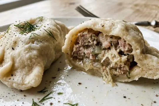 Pyszne pierogi z białą kiełbasą, okraszone koperkiem i pieprzem, kuszą obfitym farszem.