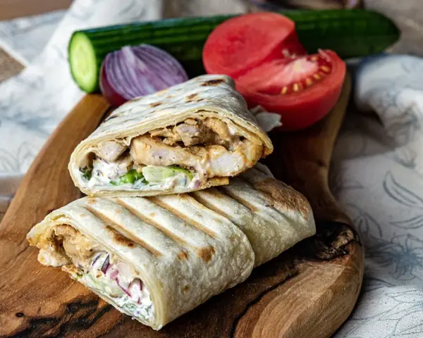 Pyszny domowy kebab w tortilli z kurczakiem, warzywami i sosem. Idealny na szybki obiad.