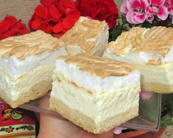 Pyszny sernik z rosą z wiaderka, z puszystą pianką i kruchym spodem, otoczony kwitnącymi pelargoniami.
