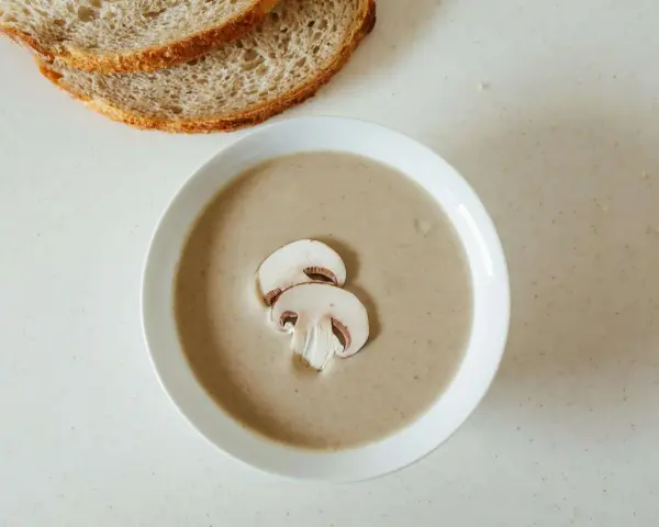 Kremowa zupa pieczarkowa z pieczywem. Jakie przyprawy do zupy pieczarkowej? Sól, pieprz, gałka muszkatołowa i tymianek podkreślą jej smak.