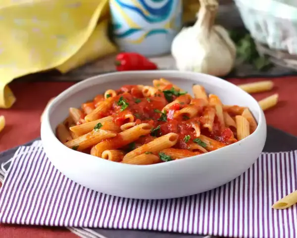 Penne w sosie pomidorowym, posypane natką pietruszki. Pyszny makaron z cukrem, który zachwyci każdego.