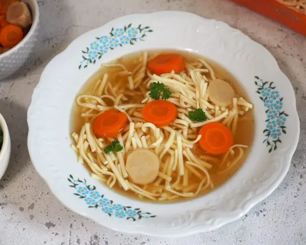 Aksamitny rosół z kaczki z makaronem nitki, marchewką i kawałkami mięsa. Idealny na chłodne dni.