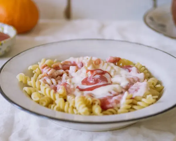 Fusilli z kremowym sosem i kawałkami owoców. Pyszny makaron na słodko, idealny na deser.