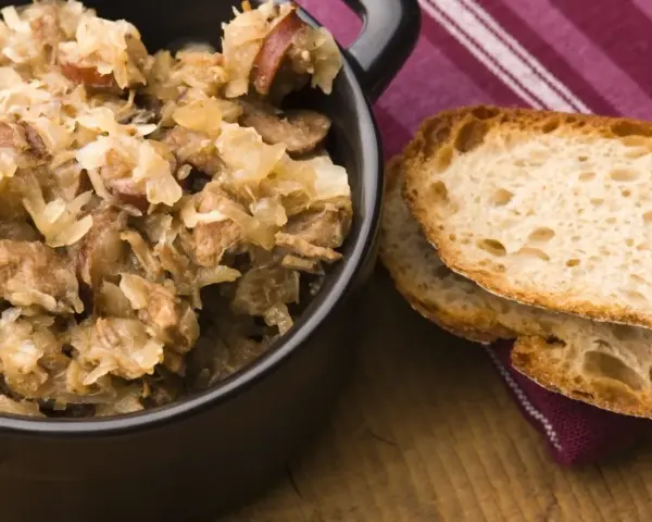 Pyszny bigos z różnymi rodzajami mięsa, podany z chrupiącym chlebem. Idealny wybór, jeśli zastanawiasz się, jakie mięso do bigosu wybrać.