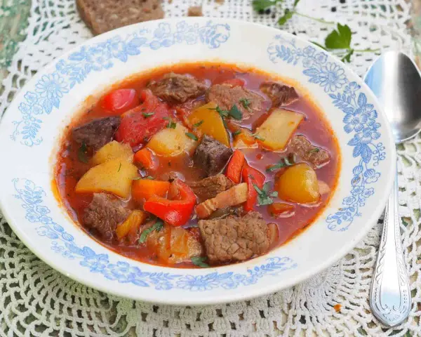 Aksamitna zupa gulaszowa przepis: sycące kawałki wołowiny, ziemniaki, papryka i marchewka w aromatycznym, pomidorowym sosie.