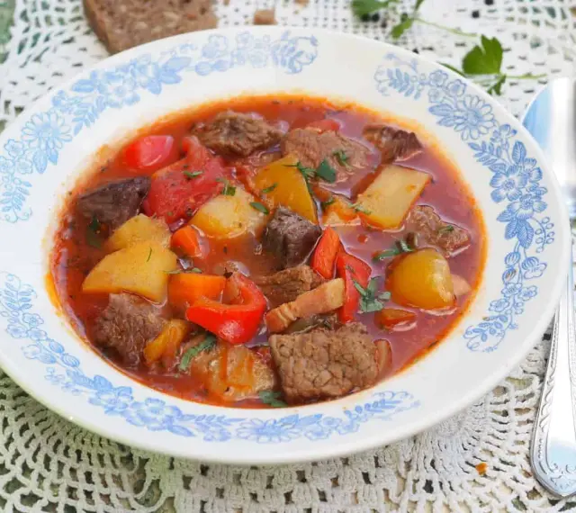 Aksamitna zupa gulaszowa przepis: sycące kawałki wołowiny, ziemniaki, papryka i marchewka w aromatycznym, pomidorowym sosie.