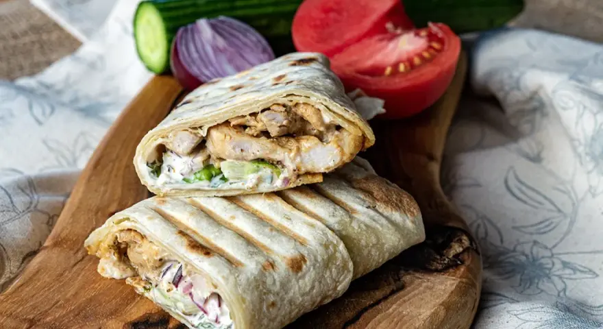 Pyszny domowy kebab w tortilli z kurczakiem, warzywami i sosem. Idealny na szybki obiad.