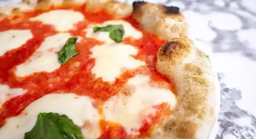 Puszyste ciasto na pizzę z sosem pomidorowym, ciągnącą się mozzarellą i listkami bazylii. Idealne na wieczór z przyjaciółmi.