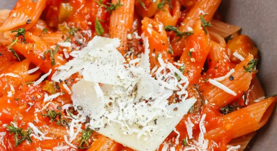 Pyszne dania z makaronem penne w sosie pomidorowym z parmezanem i ziołami. Idealne na szybki obiad.