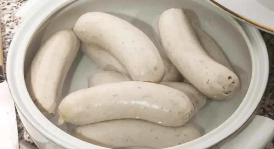 Biała kiełbasa w garnku, gotowa do przygotowania według przepisu.