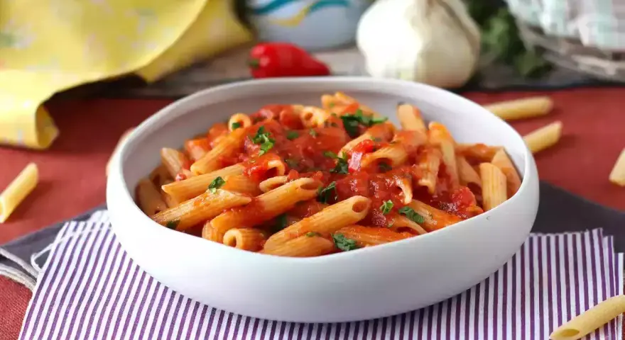 Penne w sosie pomidorowym, posypane natką pietruszki. Pyszny makaron z cukrem, który zachwyci każdego.
