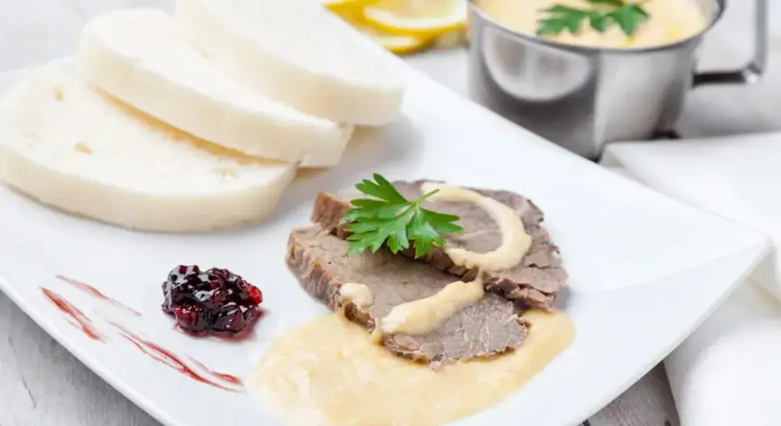 Plasterki pieczonego schabu z sosem, knedliki, konfitura z owoców leśnych i sos do schabu pieczonego w sosjerce.