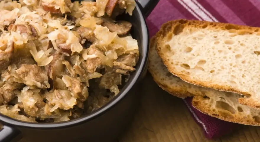 Pyszny bigos z różnymi rodzajami mięsa, podany z chrupiącym chlebem. Idealny wybór, jeśli zastanawiasz się, jakie mięso do bigosu wybrać.