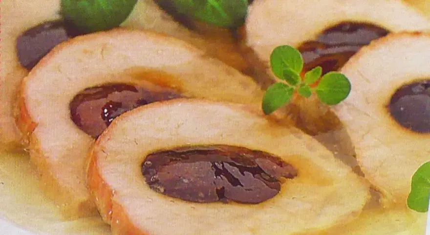 Schab ze śliwką w galarecie, elegancko pokrojony, z ziołami. Pyszne danie, które zachwyca smakiem i wyglądem.