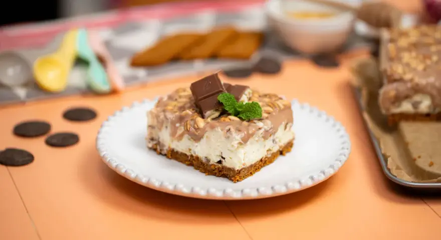 Pyszny deser Kinder Country na kruchym spodzie, polany czekoladą i posypany orzeszkami. Idealny na każdą okazję!