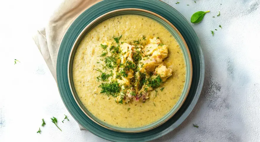 Aksamitna zupa z zielonego groszku z puszki, udekorowana puree ziemniaczanym i świeżym koperkiem.