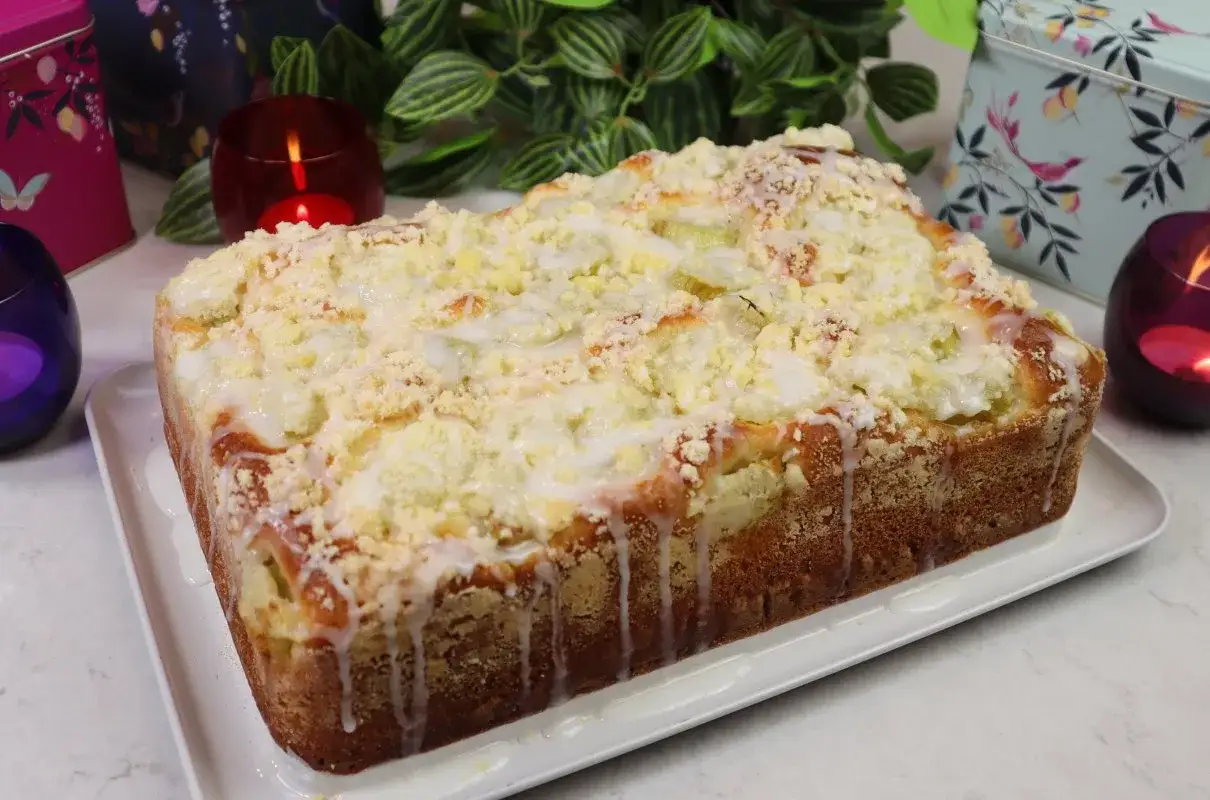 Puszyste ciasto drożdżowe z rabarbarem, posypane kruszonką i polane lukrem. Idealne na wiosenne popołudnie.