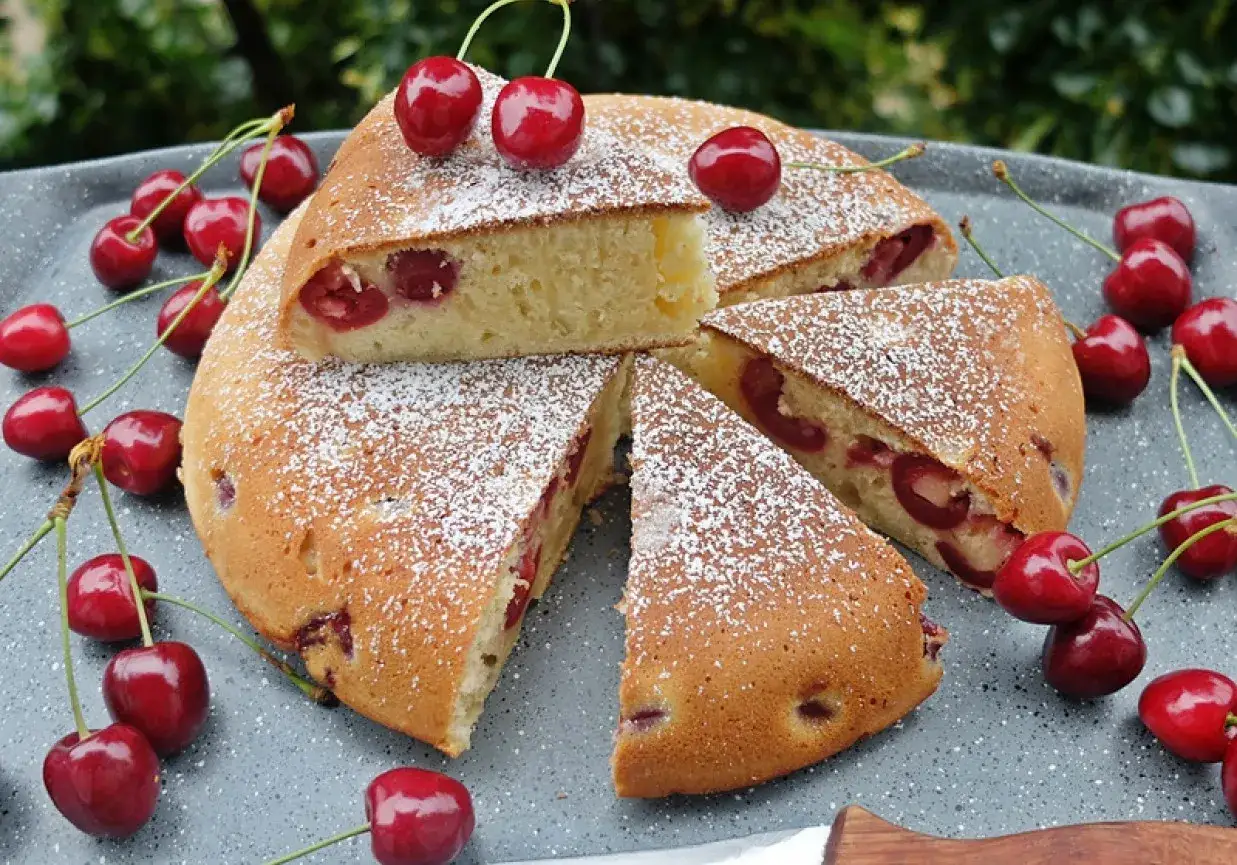 Pyszne ciasto z patelni z wiśniami, posypane cukrem pudrem. Idealne na letnie popołudnie.