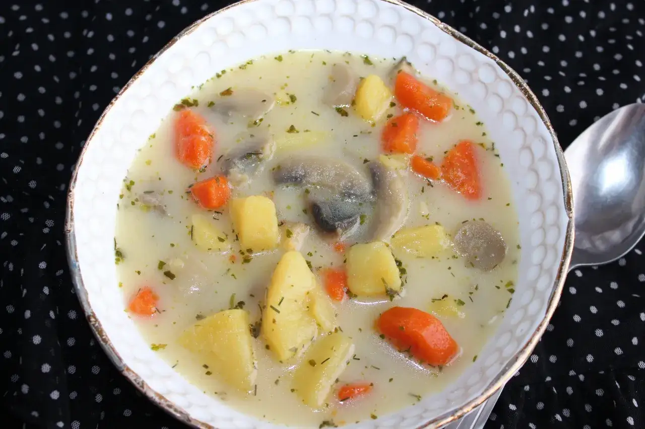 Aksamitna zupa pieczarkowa z ziemniakami i marchewką, posypana natką pietruszki. Idealna na chłodne dni.