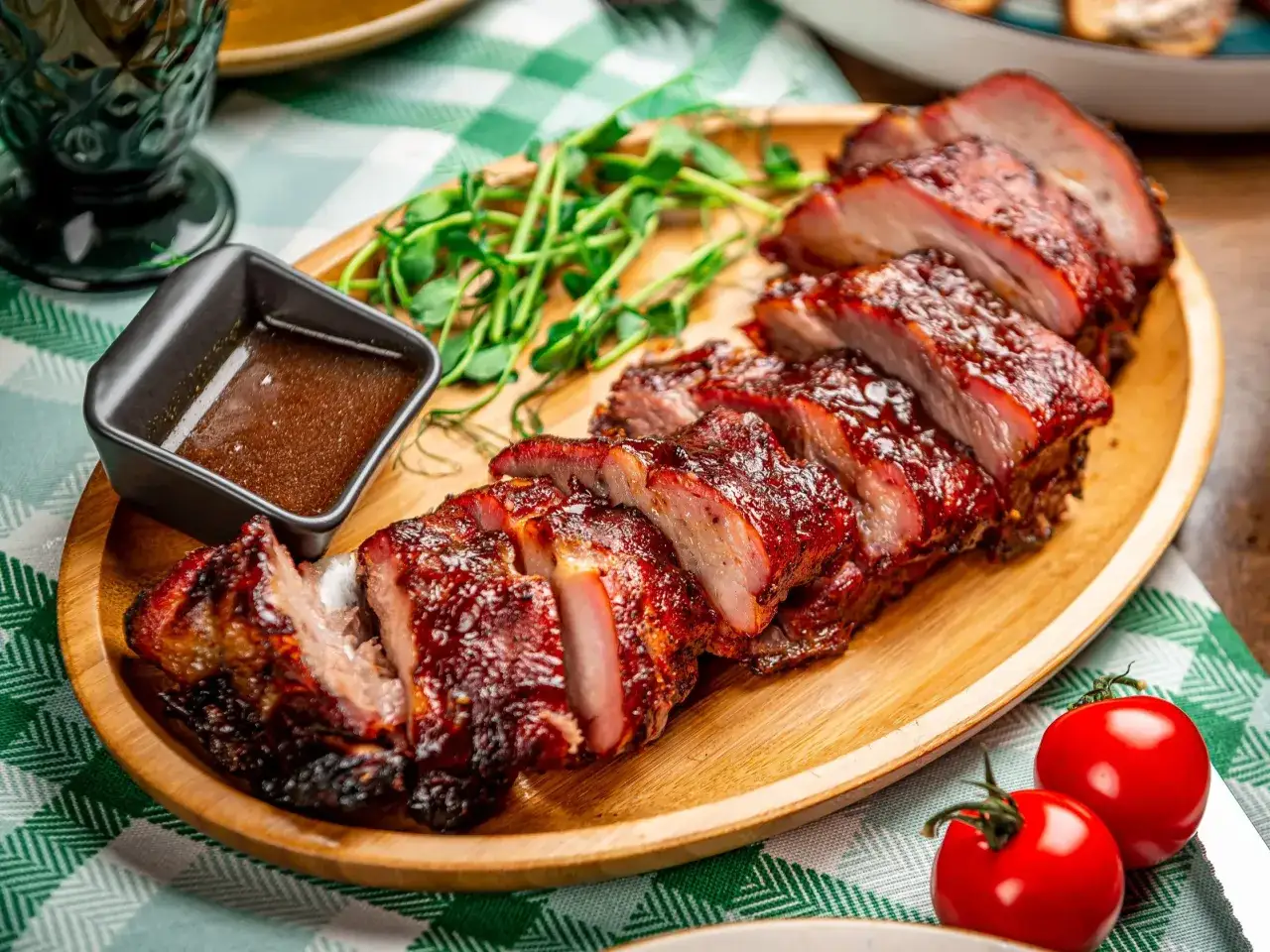 Soczyste żeberka w sosie barbecue, podane z kiełkami i pomidorkami. Idealne, by dowiedzieć się, jak przyprawić żeberka.