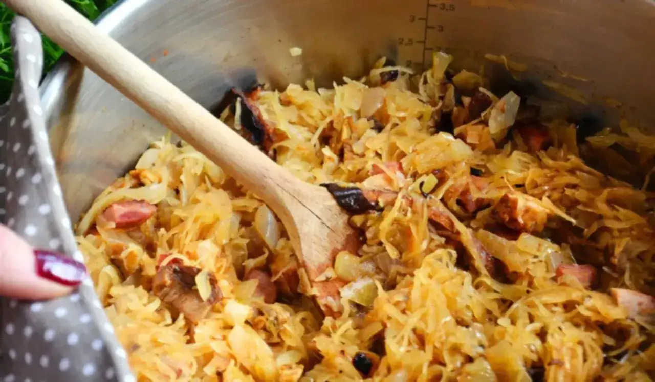 Gotujesz bigos? Zobacz, jakie mięso do bigosu najlepiej pasuje, by danie było aromatyczne i sycące. Widoczny gar bigosu z kapustą i kawałkami mięsa.