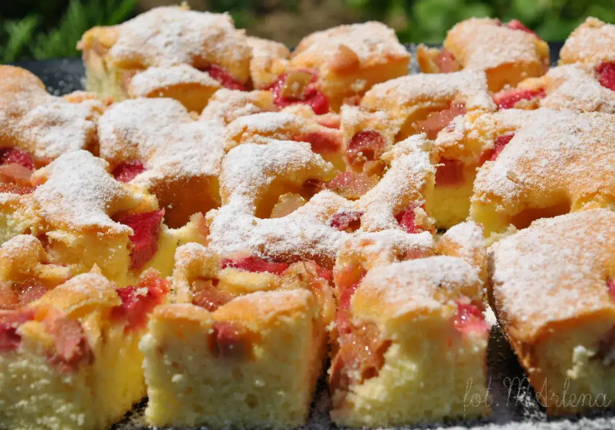 Szybkie ciasto z rabarbarem na oleju, posypane cukrem pudrem, wygląda apetycznie. Idealne na letnie popołudnie.