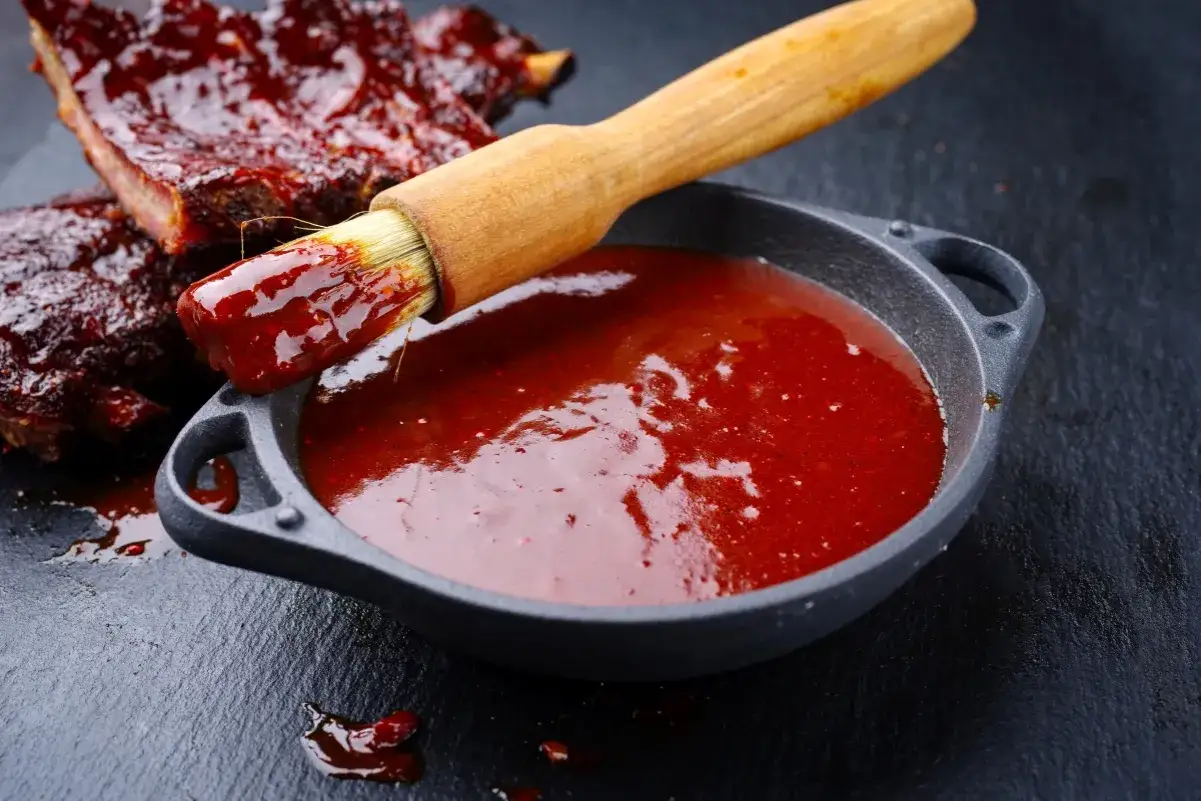 Pyszne żeberka w sosie BBQ, pędzelek zanurzony w sosie, idealny sos bbq przepis.