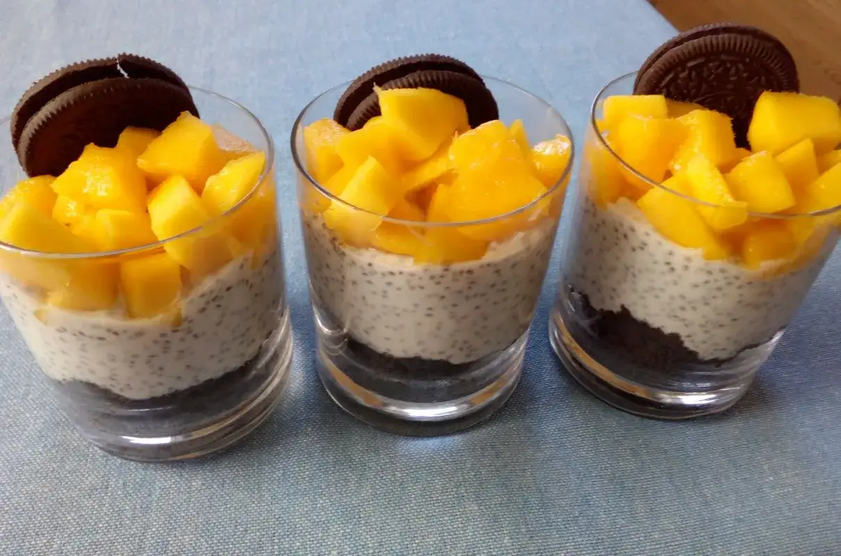 Pyszny deser z mango, nasion chia i pokruszonych ciastek Oreo w szklankach.