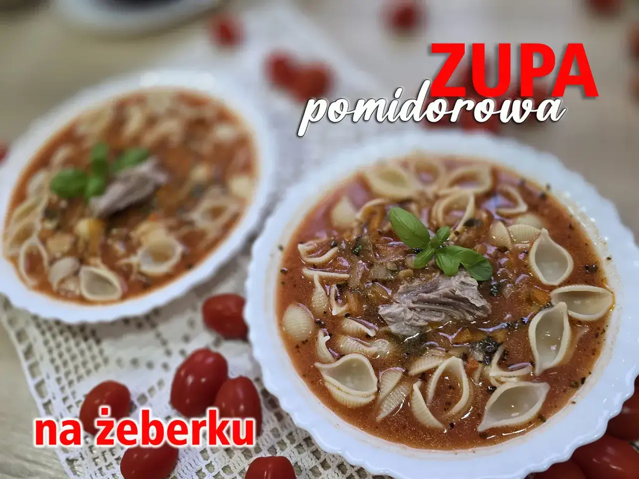 Dwie porcje pysznej pomidorowej na żeberku, ozdobione bazylią i muszelkami makaronu.