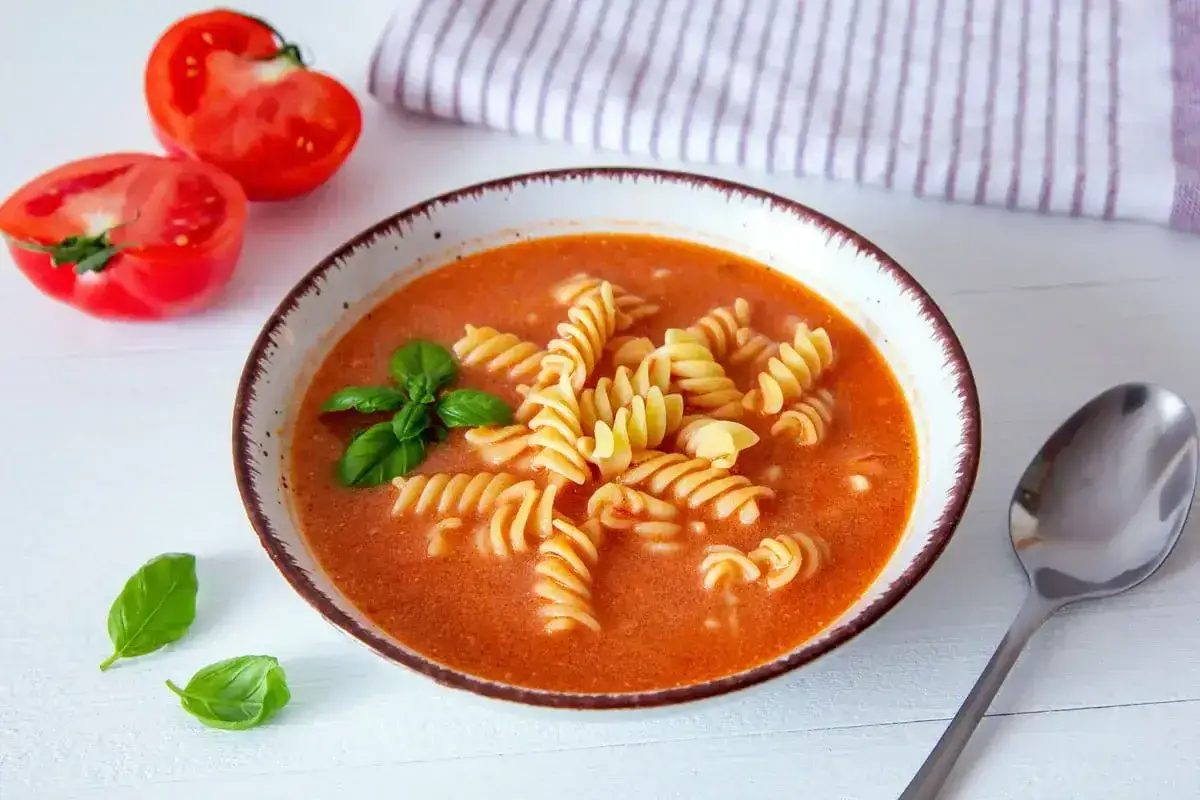Zupa pomidorowa z makaronem fusilli i bazylią. Jakie przyprawy do zupy pomidorowej? Sól, pieprz, czosnek, zioła prowansalskie.