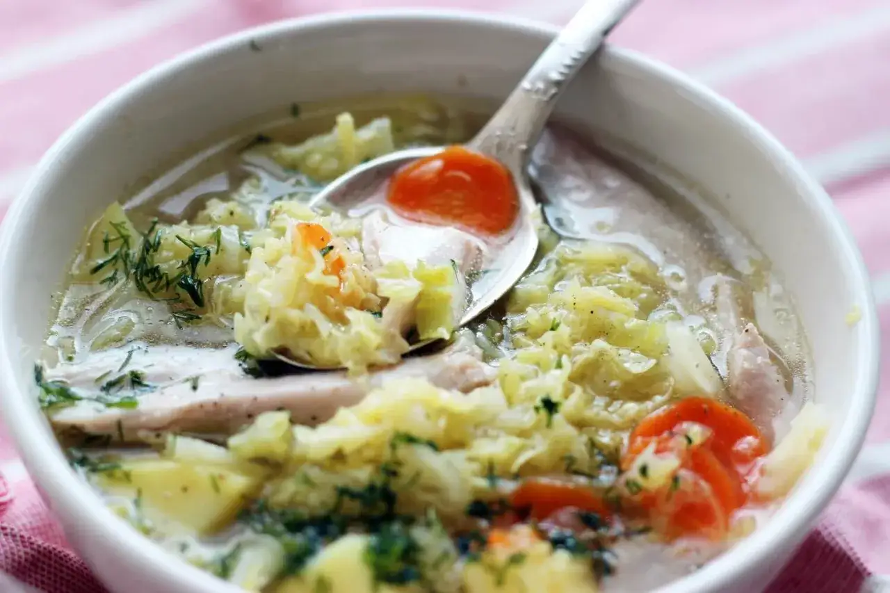 Aromatyczna zupa z kapusty włoskiej z kawałkami mięsa, ziemniaków i marchewki, doprawiona świeżym koprem.