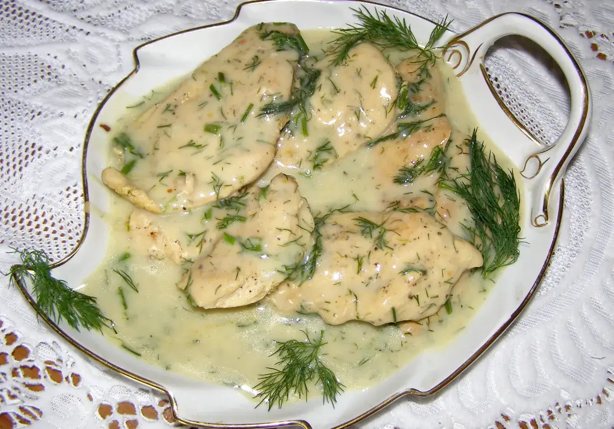 Pyszna pierś z kurczaka w sosie śmietanowym z koperkiem, podana w ozdobnej misie.