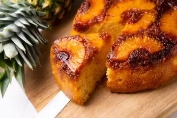 Pyszne ciasto z patelni z ananasem i karmelizowaną skórką, obok świeży ananas.